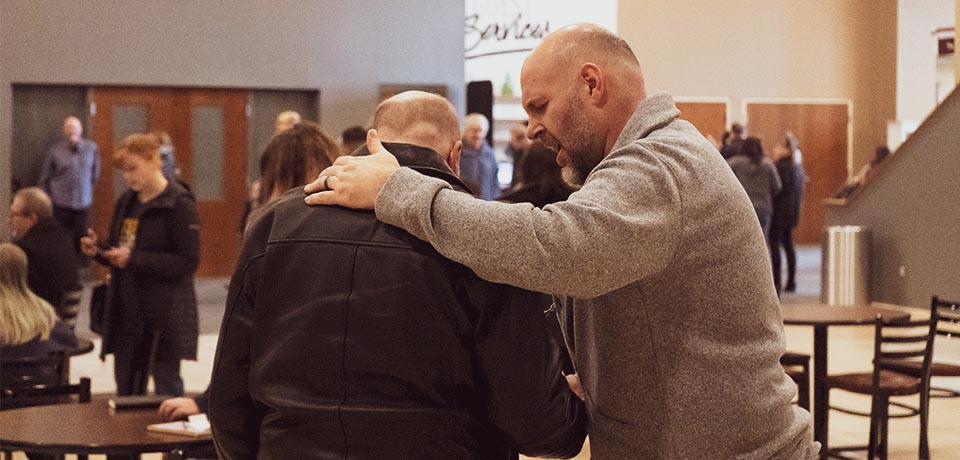 Man praying for another man