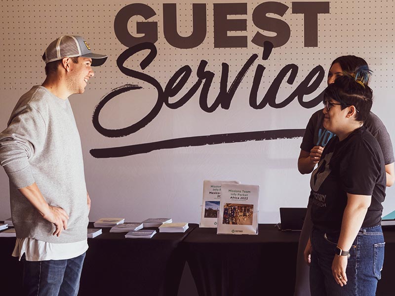 Visitor being welcomed at Victory Family Church's Guest Services table