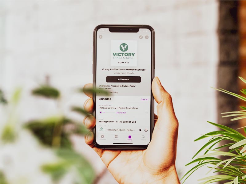 Person holding a smartphone with the Victory Family Church podcast page open