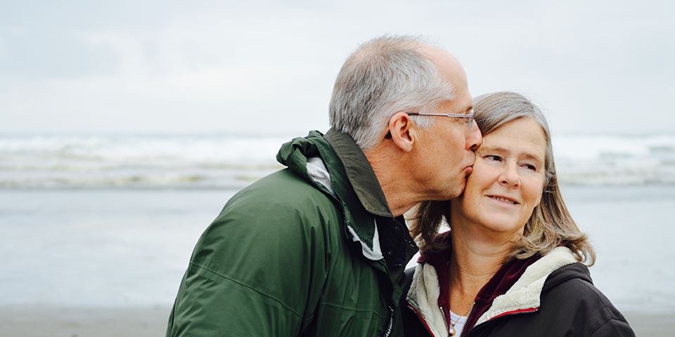 Married couple kissing on a beach