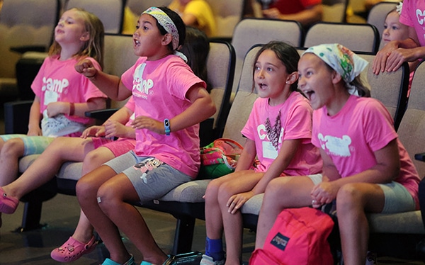 Young girls in the auditorium at Victory Kids Camp